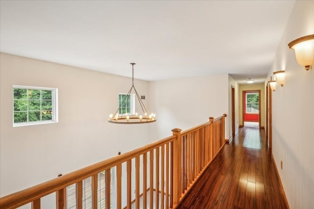 hallway featuring an inviting chandelier and dark wood-type flooring