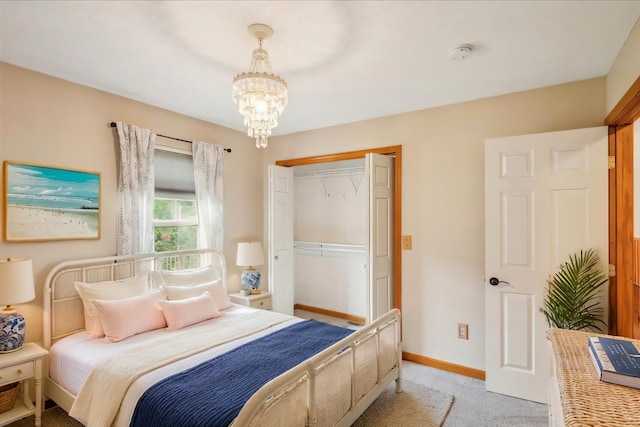 bedroom with a closet, carpet floors, and an inviting chandelier