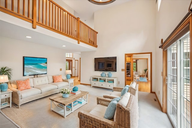 living room featuring light carpet and a high ceiling