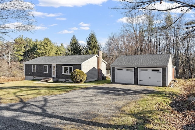 ranch-style house featuring an outbuilding, a garage, and a front lawn