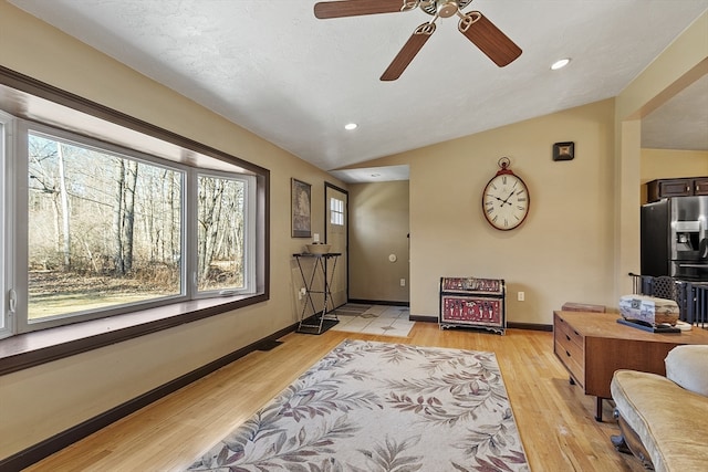 interior space featuring a textured ceiling, ceiling fan, light hardwood / wood-style floors, and lofted ceiling