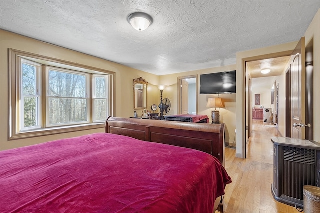 bedroom with light hardwood / wood-style flooring and a textured ceiling