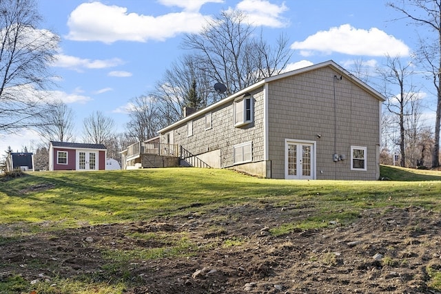 view of side of home featuring a lawn and french doors