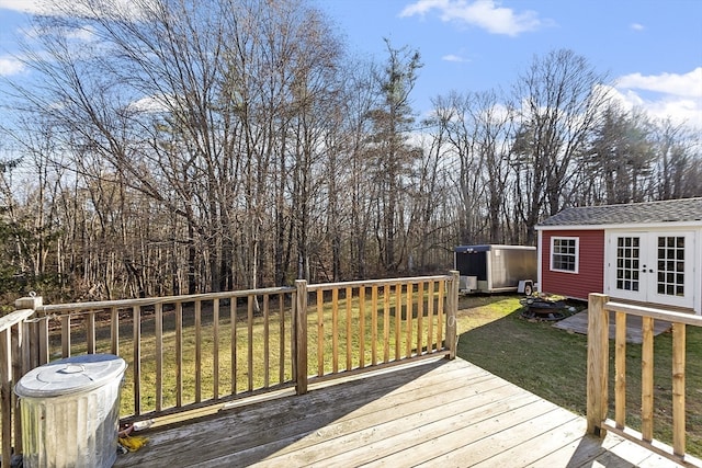 wooden deck with an outbuilding and a lawn