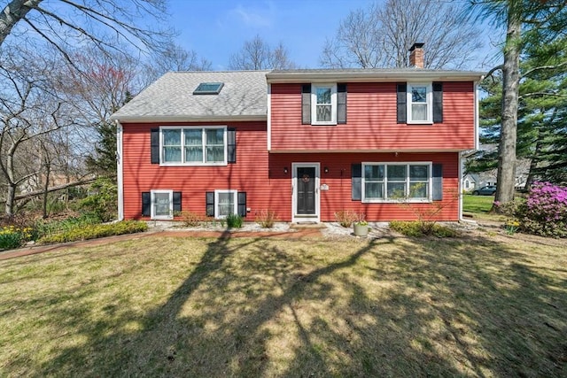 split level home featuring a front lawn, a chimney, entry steps, and roof with shingles