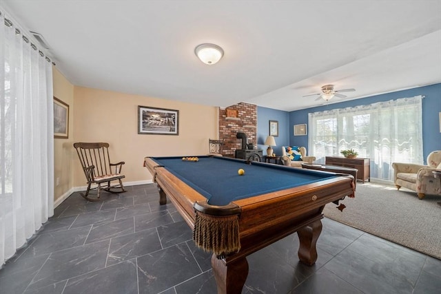 game room with baseboards, a ceiling fan, a wood stove, and pool table