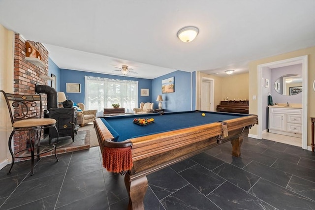 recreation room featuring baseboards, a ceiling fan, pool table, and a wood stove