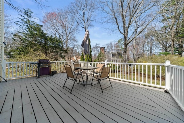 wooden terrace featuring outdoor dining area and grilling area