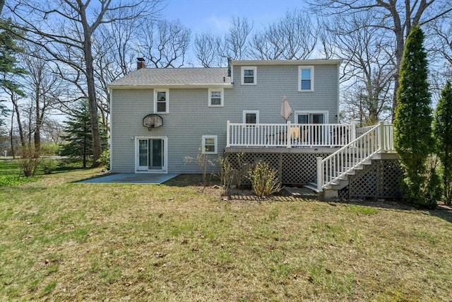 rear view of house featuring a chimney, a deck, a yard, a patio, and stairs