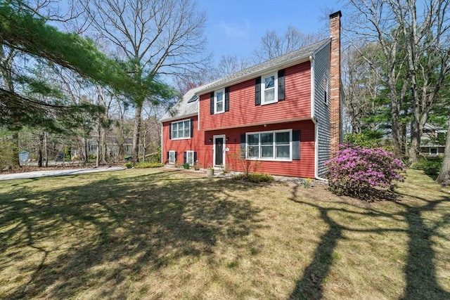 view of front of home featuring a front lawn and a chimney