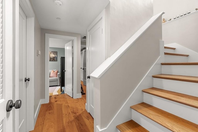 staircase featuring baseboards and wood finished floors