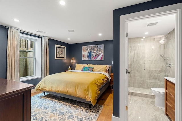 bedroom with connected bathroom, visible vents, and recessed lighting