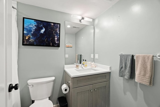bathroom with vanity, toilet, and visible vents
