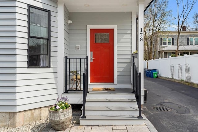 view of exterior entry featuring fence