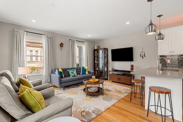 living room with light wood-style flooring, a healthy amount of sunlight, and recessed lighting