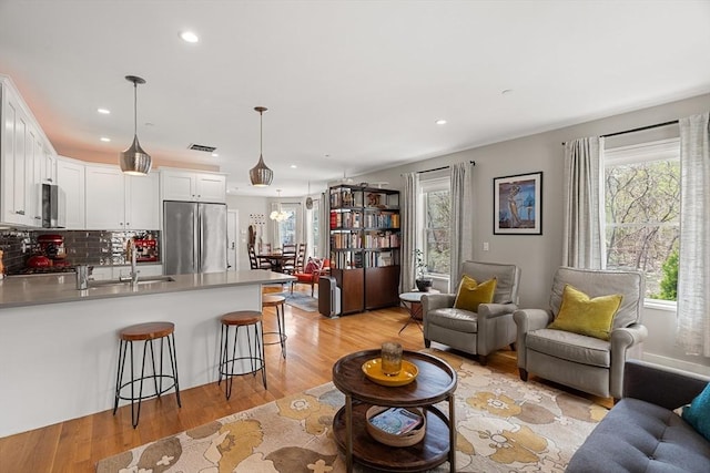 living room with light wood-style flooring, a wealth of natural light, and recessed lighting