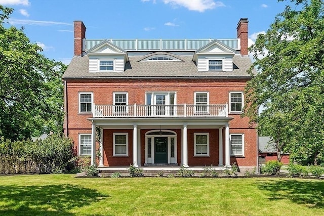 view of front of property with a balcony, a chimney, and a porch