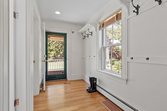 doorway to outside with a baseboard heating unit, plenty of natural light, light wood-style floors, and recessed lighting