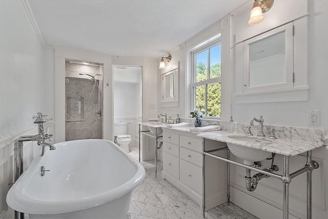 bathroom with marble look tile flooring, a shower stall, a freestanding bath, toilet, and double vanity