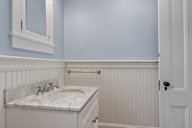 bathroom with a wainscoted wall and vanity
