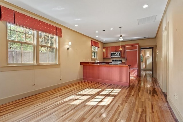 kitchen with stainless steel microwave, light wood-style flooring, baseboards, range, and recessed lighting