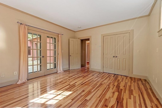 unfurnished bedroom featuring french doors, light wood-type flooring, ornamental molding, baseboards, and access to outside