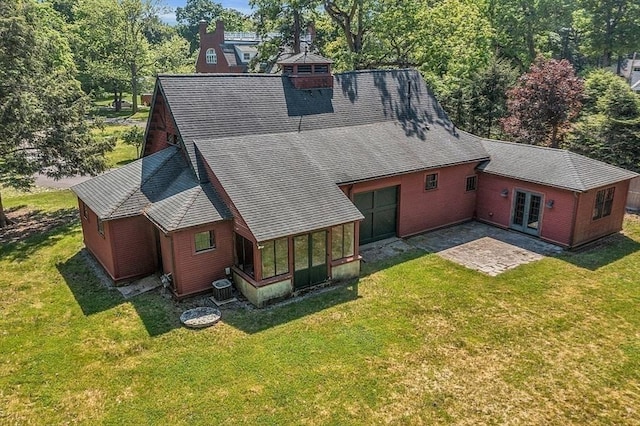 rear view of house with roof with shingles, french doors, a sunroom, and a chimney