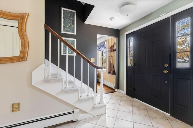 entrance foyer featuring baseboards, a baseboard heating unit, light tile patterned floors, and stairway