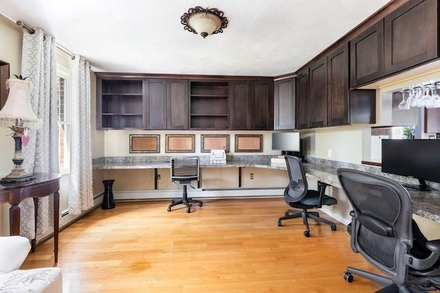office space featuring light wood-style flooring and built in study area