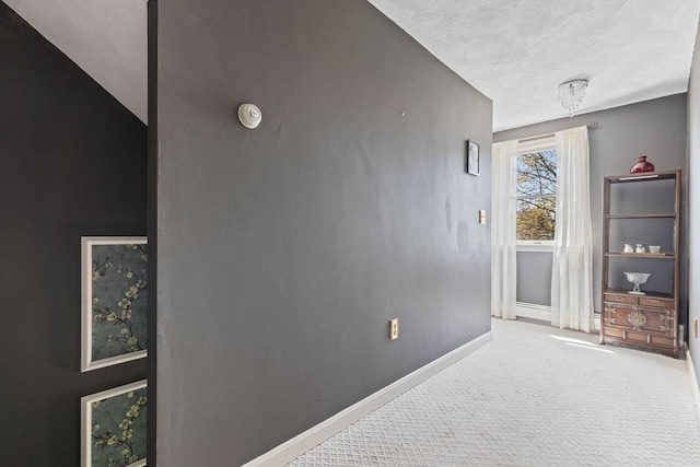 carpeted spare room featuring baseboards