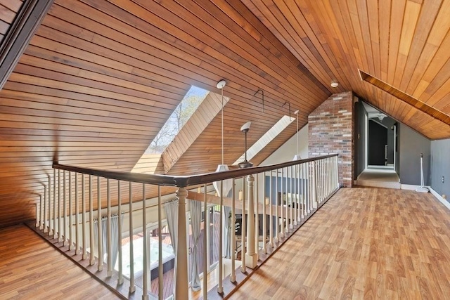 bonus room featuring vaulted ceiling with skylight, wood ceiling, a healthy amount of sunlight, wood finished floors, and baseboards