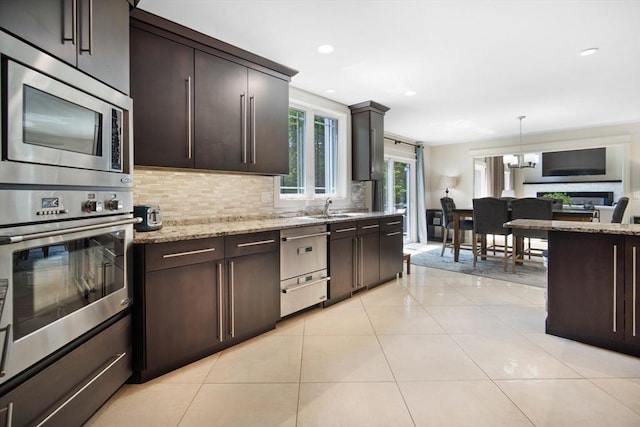 2 Nikkis Way, Hadley, MA 01035 - kitchen featuring appliances with stainless steel finishes, backsplash, dark brown cabinets, light stone countertops, and recessed lighting