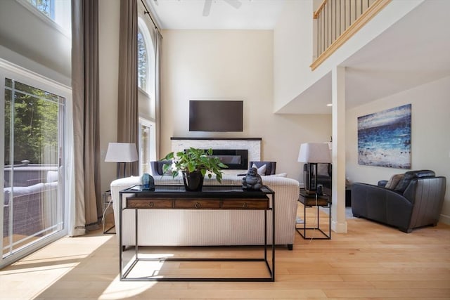2 Nikkis Way, Hadley, MA 01035 - living room featuring hardwood / wood-style floors, a glass covered fireplace, a towering ceiling, and ceiling fan