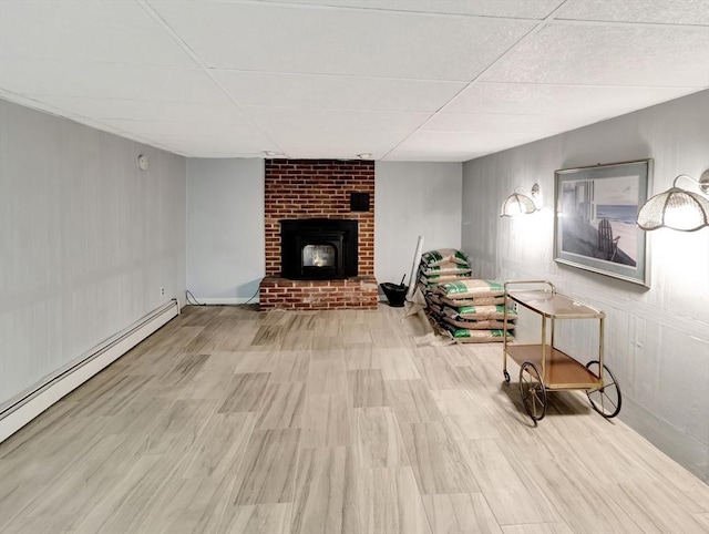 442 Purchase St, Easton, MA 02375 - living area with baseboard heating, a drop ceiling, wood finished floors, a brick fireplace, and baseboards