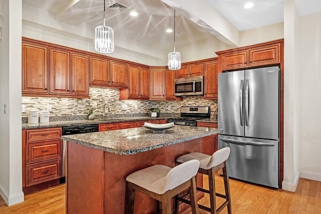 16 Green St Unit 11, Ipswich, MA 01938 - kitchen with appliances with stainless steel finishes, light wood-style flooring, backsplash, baseboards, and a center island