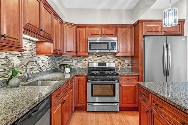 16 Green St Unit 11, Ipswich, MA 01938 - kitchen with appliances with stainless steel finishes, a sink, light wood-style floors, dark stone countertops, and decorative backsplash