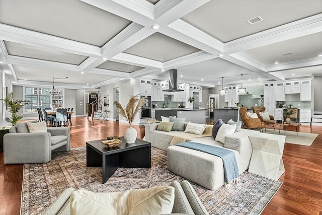 living room with an inviting chandelier, coffered ceiling, dark hardwood / wood-style floors, and beamed ceiling