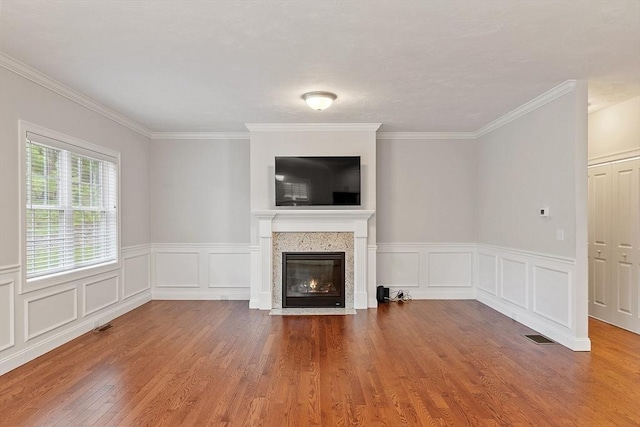 295 Sewall St Unit 295, Boylston, MA 01505 - unfurnished living room featuring wood finished floors, a fireplace with flush hearth, crown molding, a decorative wall, and wainscoting