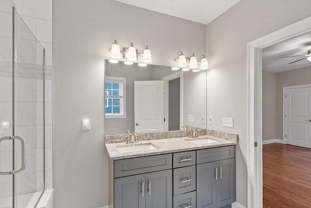 295 Sewall St Unit 295, Boylston, MA 01505 - bathroom featuring double vanity, tiled shower, wood finished floors, baseboards, and a ceiling fan