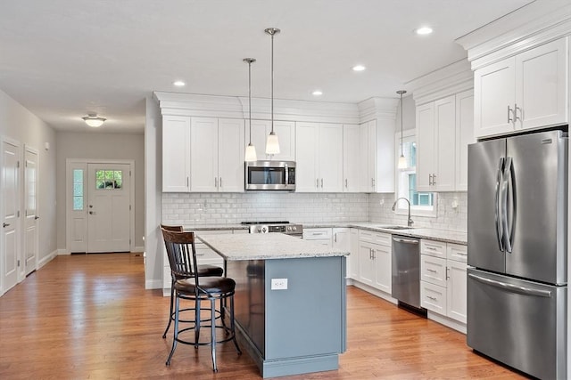 295 Sewall St Unit 295, Boylston, MA 01505 - kitchen featuring stainless steel appliances, a sink, a kitchen island, white cabinets, and a kitchen bar