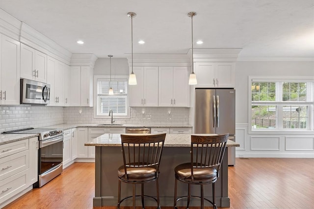 295 Sewall St Unit 295, Boylston, MA 01505 - kitchen with appliances with stainless steel finishes, a sink, white cabinets, light wood finished floors, and ornamental molding