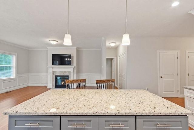 295 Sewall St Unit 295, Boylston, MA 01505 - kitchen featuring gray cabinetry, wood finished floors, crown molding, light stone counters, and open floor plan