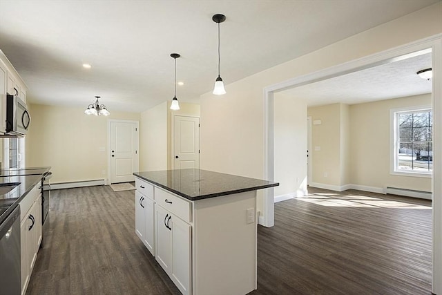 kitchen with decorative light fixtures, white cabinets, appliances with stainless steel finishes, and a kitchen island