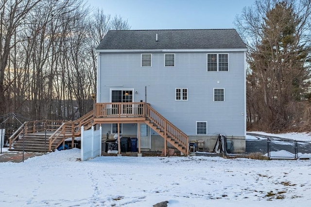 snow covered rear of property featuring a deck