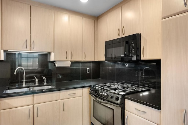 kitchen with black microwave, stainless steel gas stove, a sink, light brown cabinetry, and backsplash