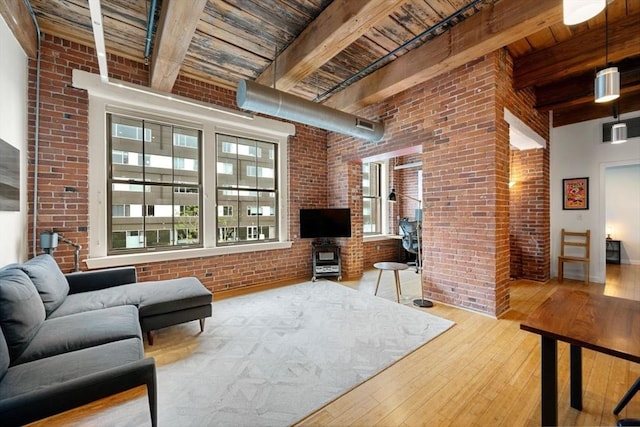 living room with hardwood / wood-style flooring, brick wall, beamed ceiling, and wooden ceiling