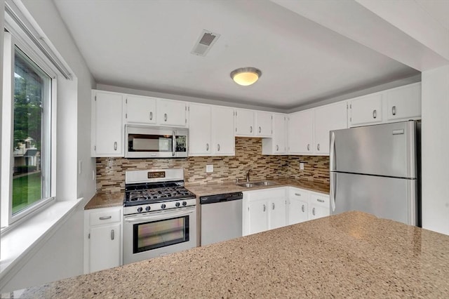 360 Littleton Unit D1, Chelmsford, MA 01824 - kitchen with appliances with stainless steel finishes, a sink, backsplash, white cabinetry, and light stone countertops