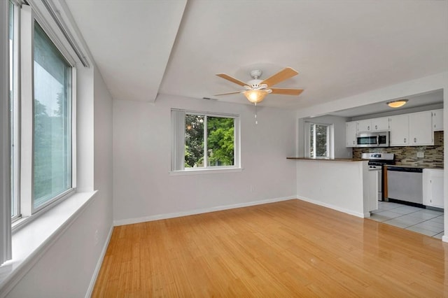 360 Littleton Unit D1, Chelmsford, MA 01824 - unfurnished living room featuring light wood-style flooring, baseboards, and a ceiling fan