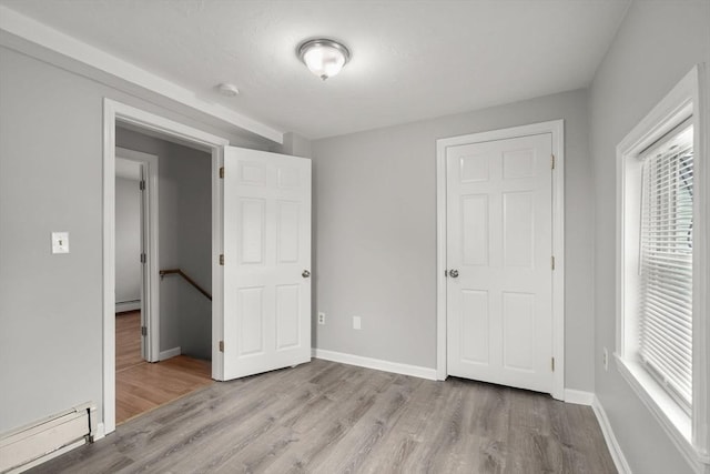 78-82 3rd St, Lowell, MA 01850 - unfurnished bedroom with baseboard heating, wood finished floors, and multiple windows