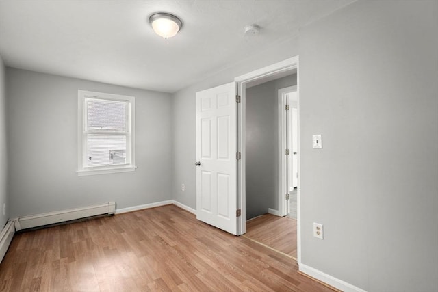 78-82 3rd St, Lowell, MA 01850 - empty room featuring light wood-type flooring, a smoke detector, and a baseboard radiator